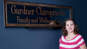 Dr-Jennifer-Gardner-Standing-by-Gardner-Chiropractic-Family-and-Wellness-Center-Sign